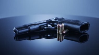 9mm gun rotating on a reflective surface