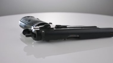 9mm gun rotating on a reflective surface