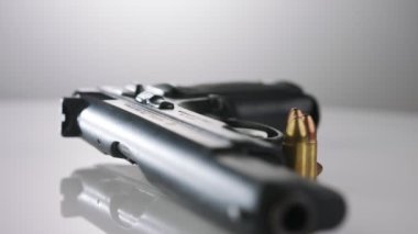 9mm gun rotating on a reflective surface