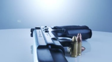 9mm gun rotating on a reflective surface