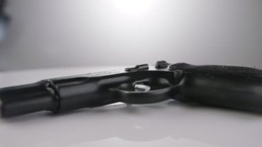 9mm gun rotating on a reflective surface