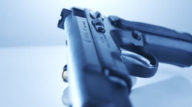 9mm gun rotating on a reflective surface