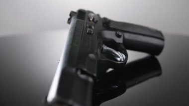 9mm gun rotating on a reflective surface