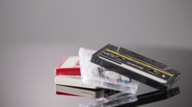 Audio cassettes rotating on a reflective surface