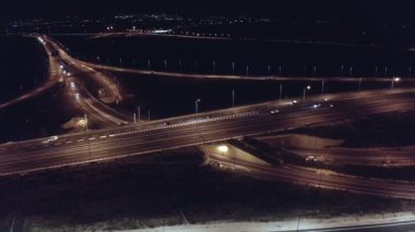 Aerial shot of a large highway at night with cars driving