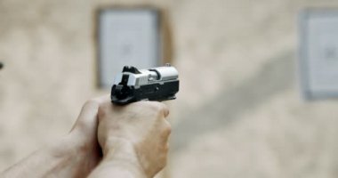 Slow motion of a hand gun firing with cartridge flying away
