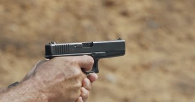 Slow motion of a hand gun firing with cartridge flying away