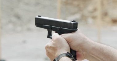 Pistol shooting bullets in slow motion footage. Hand guns in shooting range