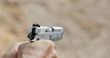 Pistol shooting bullets in slow motion footage. Hand guns in shooting range