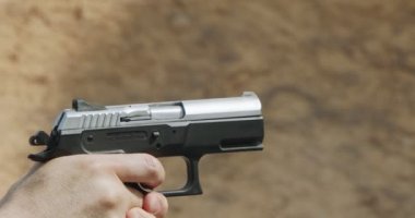 Slow motion of a hand gun firing with cartridge flying away