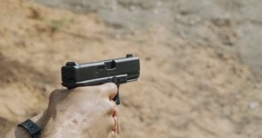 Slow motion of a hand gun firing with cartridge flying away