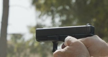 Slow motion of a hand gun firing with cartridge flying away