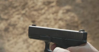 Slow motion of a hand gun firing with cartridge flying away