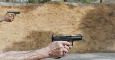 Pistol shooting bullets in slow motion footage. Hand guns in shooting range