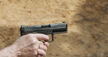 Pistol shooting bullets in slow motion footage. Hand guns in shooting range