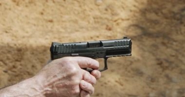 Slow motion of a hand gun firing with cartridge flying away