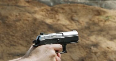 Slow motion of a hand gun firing with cartridge flying away