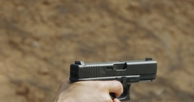 Pistol shooting bullets in slow motion footage. Hand guns in shooting range