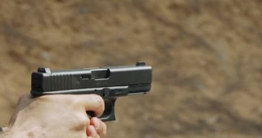 Slow motion of a hand gun firing with cartridge flying away