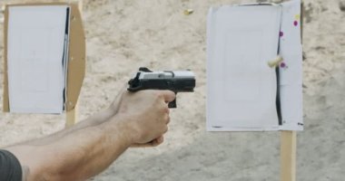 Slow motion of a hand gun firing with cartridge flying away