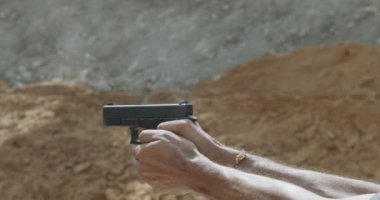 Slow motion of a hand gun firing with cartridge flying away