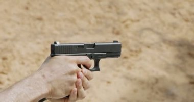 Slow motion of a hand gun firing with cartridge flying away
