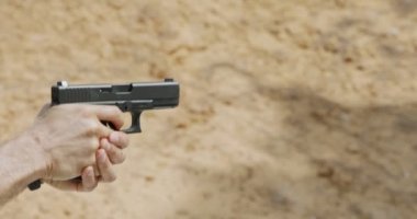 Slow motion of a hand gun firing with cartridge flying away