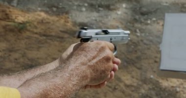 Slow motion of a hand gun firing with cartridge flying away