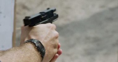 Slow motion close up shot of a man shooting a hand gun while moving