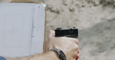 Slow motion close up shot of a man shooting a hand gun while moving