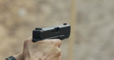 hand gun firing with cartridge flying away
