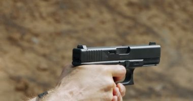 hand gun firing with cartridge flying away