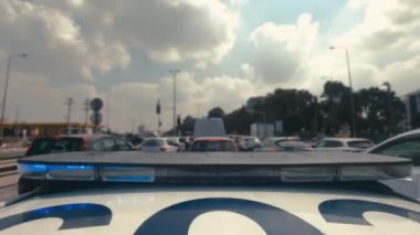 Şehrin sokaklarında mavi ve kırmızı ışıklarla giden polis arabasının zamanı.