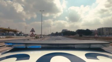 Şehrin sokaklarında mavi ve kırmızı ışıklarla giden polis arabasının zamanı.