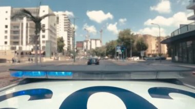 Şehrin sokaklarında mavi ve kırmızı ışıklarla giden polis arabasının zamanı.