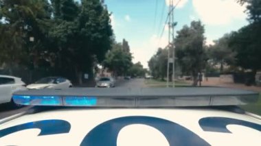 Şehrin sokaklarında mavi ve kırmızı ışıklarla giden polis arabasının zamanı.