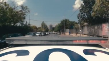 Şehrin sokaklarında mavi ve kırmızı ışıklarla giden polis arabasının zamanı.