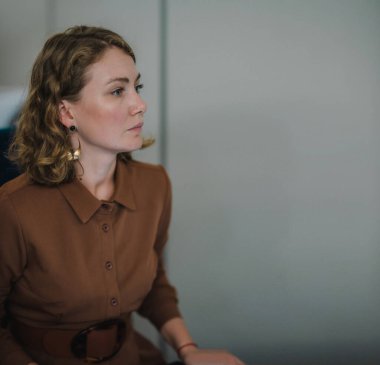 Kahverengi elbiseli bir kadının yan portresi