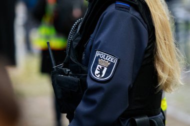 Bir polis memurunun ceketinde Alman Polisi Berlin arması var..