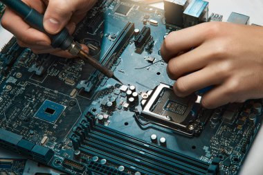 Bir adam elektronik aletleri tamir etmek için bir araç tutar, lehim devre kartını elle monte eder.