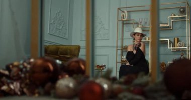 Portrait of a desperate rich woman in her thirties, looking around. Sad frustrated depressive caucasian lady in elegant dress at home on weekend alone. Loneliness and wealth