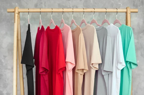 Giysi rafındaki moda kıyafetleri - parlak renkli dolap. Gökkuşağı renk seçimi mağaza dolabında ya da bahar temizliği konseptinde askılarda moda bir kadın giyer. Yazlık kıyafet..