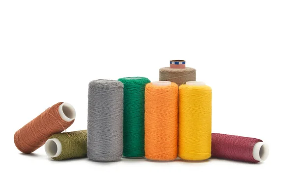 Many spools of thread of different colors scattered on a white background. — Stock Photo, Image