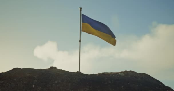 Украинский флаг. Реалистичный украинский флаг на горе трепещет на ветру на фоне заходящего солнца. — стоковое видео