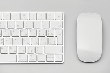 Açık gri arkaplanda klavye ve bilgisayar faresi yakın plan.