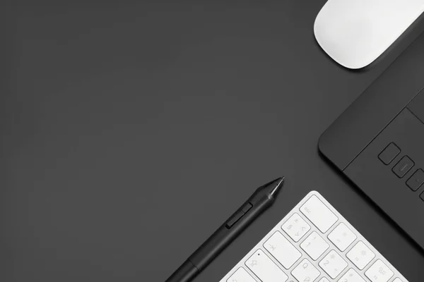Teclado de computador e mouse, caneta e tablet gráfico em um fundo preto. O conceito de criatividade moderna. — Fotografia de Stock