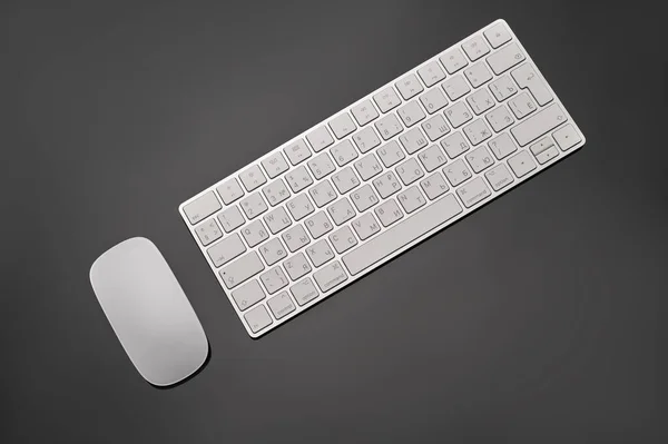 Vista superior teclado blanco y ratón sobre fondo negro. Imagen de archivo