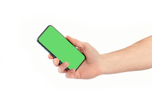 Мужчина держит смартфон с зеленым экраном, изолировать. — стоковое фото