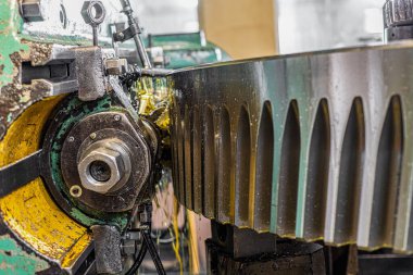 Bir dişlinin dişini dişli kesme makinesinde kesiyor..