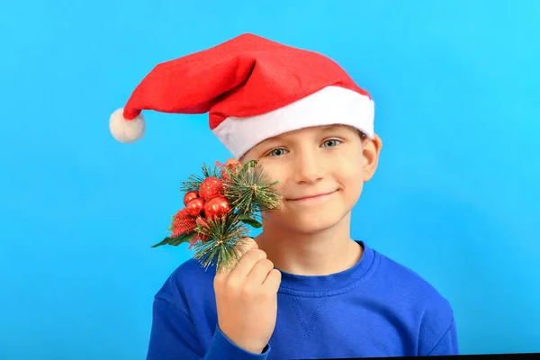 Chłopiec Czapce Świętego Mikołaja Trzyma Ręku Wystrój Świątecznych Dekoracji Gałęzi — Zdjęcie stockowe